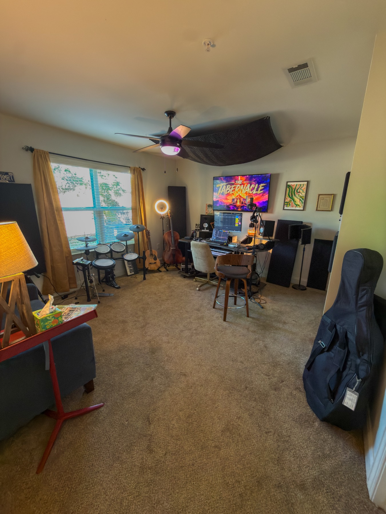 The full studio, with the drum kit by the window, guitars, and the recording desk.